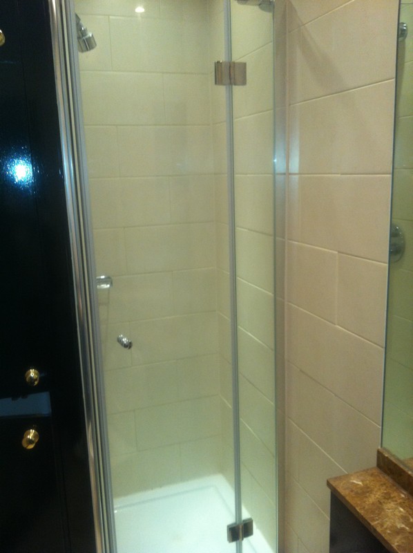 Frameless glass shower enclosure with chrome fittings in West Ealing