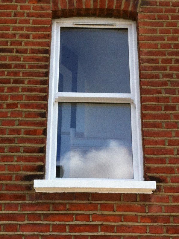uPVC sash window on Victorian red brick house in West Ealing